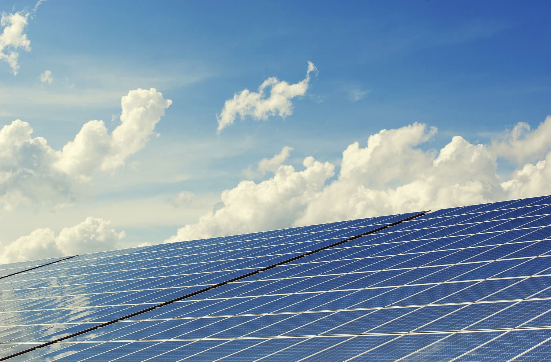 The surface of a solar array seen from below, against the sky